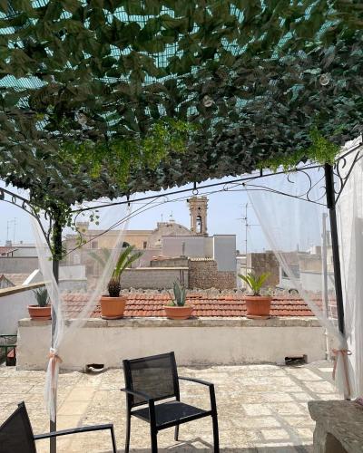a pair of chairs sitting on a patio with a building at B&B Al Castello in Sammichele di Bari