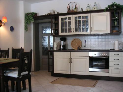 a kitchen with white cabinets and a stove at Hammerschloss Unterklingensporn in Naila