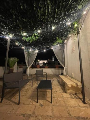 a patio with chairs and a table and lights at B&B Al Castello in Sammichele di Bari