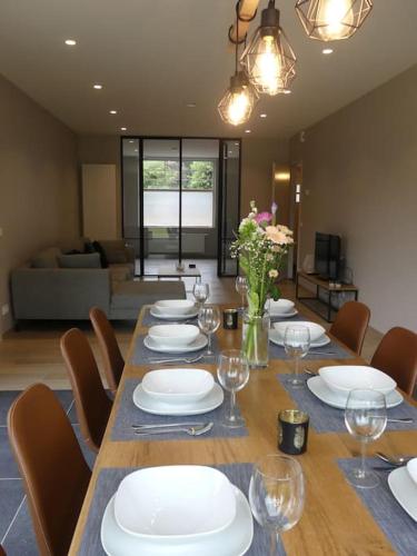 a dining room table with white plates and wine glasses at vakantiehuis Le Libr-air in Koksijde