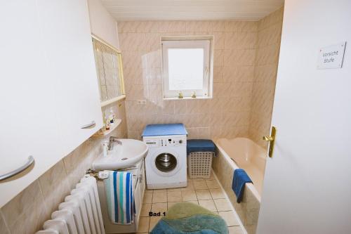 a bathroom with a washing machine and a sink at Haus Steinkamp in Blekendorf