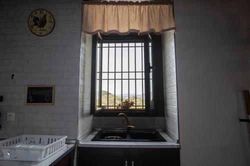 a kitchen with a sink and a window at Alojamiento turístico Loma Alta in Cambil