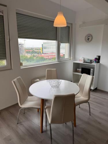 a dining room with a white table and chairs at Mall Torontal Lux Apartament in Timişoara