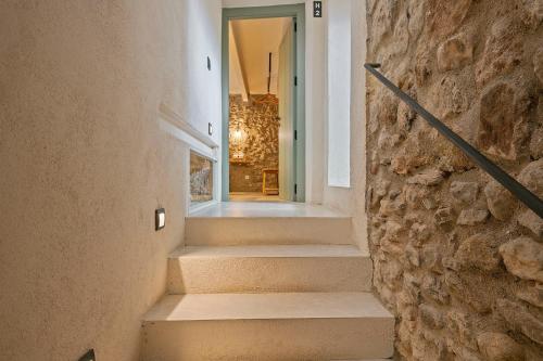a staircase in a house with a stone wall at CAN SAFRA in La Pera