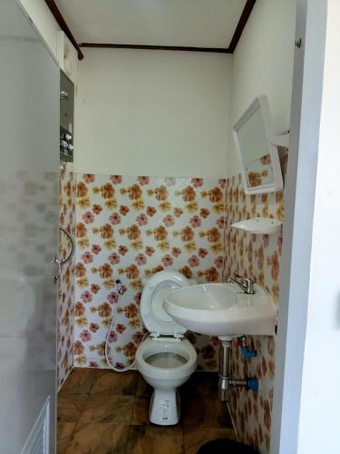 a bathroom with a toilet and a sink at Nuea Tawan at Phu Thap Buek in Ban Tha Kok Hai