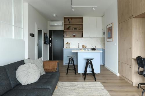 a living room with a couch and a kitchen at VIP Apartament Kopisto CENTRUM in Rzeszów