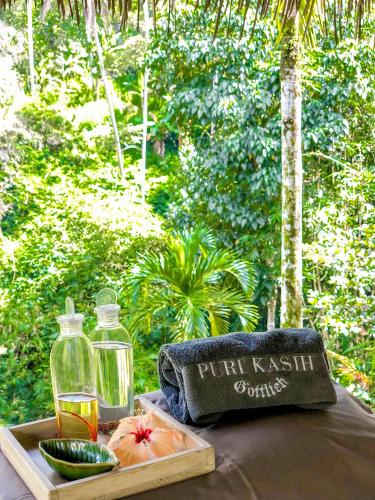 a table with a bottle of juice and a plate of food at Puri Kasih Gottlieb in Ubud