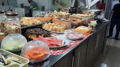 a buffet line with many different types of food at Hotel Dal Gobo in Ponta Grossa