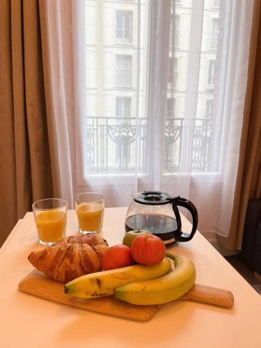- une table avec des fruits et deux verres de jus d'orange dans l'établissement Charming Studio, à Pantin