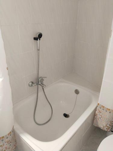 a white bath tub with a shower in a bathroom at Divertida y Romántica in Pegalajar