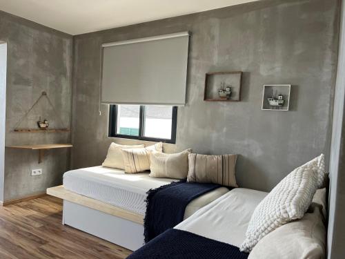 a bedroom with a bed and a window at Caniçal houses - Madeira in Caniçal