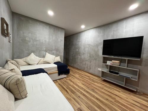 a room with two beds and a flat screen tv at Caniçal houses - Madeira in Caniçal
