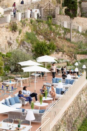 a group of people sitting in chairs and tables and umbrellas at PALAZZO SAN ROCCO in Sperlonga