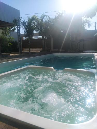 a hot tub in a pool with the sun shining at Privacidade com Hidro, piscina em casa, garagem, tudo privativo, 2 banheiros, churrasqueira e pátio amplo exclusivos, insira 3 hóspedes e abrimos 2 quartos com ar, já 5 hóspedes para 3 quartos com ar in Sorriso
