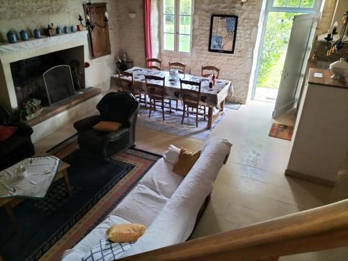 un salon avec un canapé et une salle à manger dans l'établissement Maison charmante à Antezant-la-Chapelle avec jardin, à Le Pin-Saint-Denis