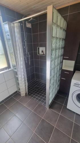 a bathroom with a shower and a washing machine at Haby House in Skene