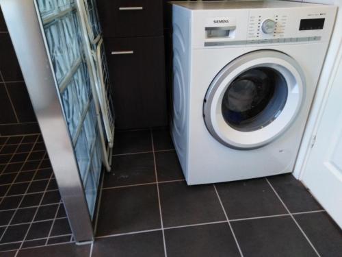 a washing machine in a laundry room with a tile floor at Haby House in Skene