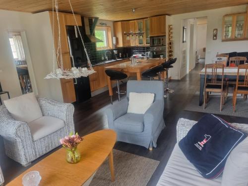 a living room with chairs and a table and a kitchen at Haby House in Skene