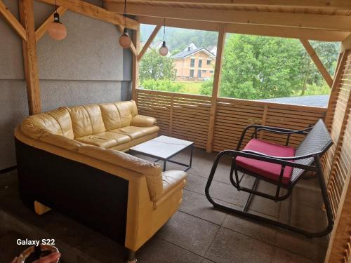 a screened in porch with a couch and two chairs at Husic Immobilien und Handwerkerservice in Rimbach