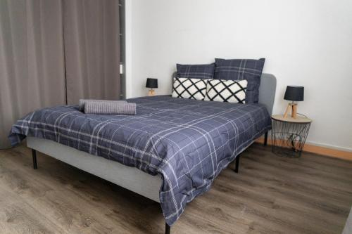 - une chambre dotée d'un lit avec une couverture bleue dans l'établissement Maison au pied du château N°2, à Châteaudun