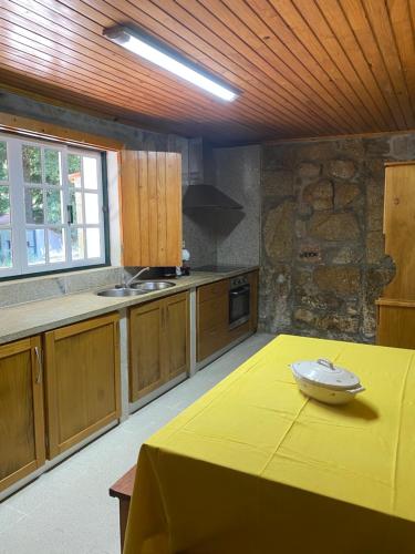 a kitchen with a table with a yellow table cloth on it at Quinta da Cavada - Casa da Tertúlia in Vouzela