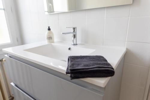 La salle de bains est pourvue d'un lavabo et d'une serviette. dans l'établissement Maison au pied du château N°2, à Châteaudun