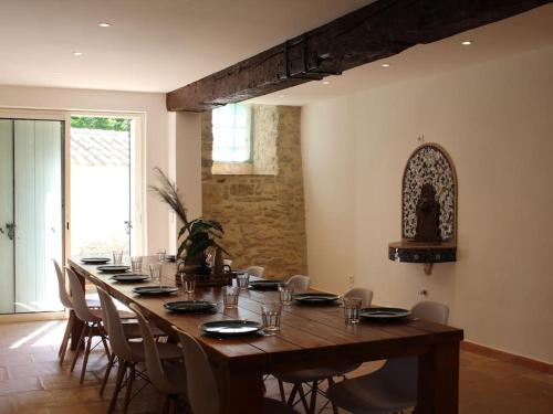 - une grande table en bois avec des chaises dans l'établissement Le Moulin, avec parc, piscine, au cœur du village, à Villegly