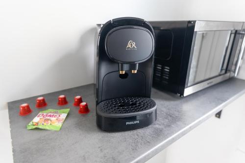 - une cafetière assise sur un comptoir à côté d'un four micro-ondes dans l'établissement Maison au pied du château N°2, à Châteaudun