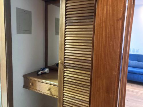 a closet with a wooden door and a wooden shelf at Recife Mar Flats Hotel in Recife