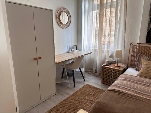 a bedroom with a desk and a bed and a table at Hotel Royal in Betzdorf