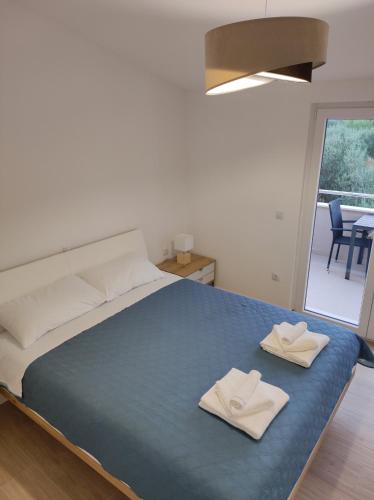 a bedroom with a bed with two white towels on it at Sweet Escape Apartments in Vinišće