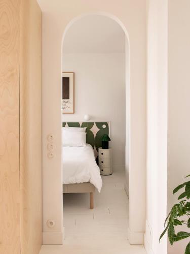 - une chambre blanche avec un lit et une voûte dans l'établissement Superbe appartement design au coeur de Versailles, tout à pied, à Versailles