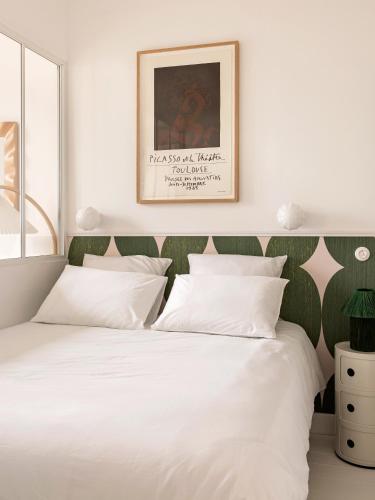 - une chambre avec un lit blanc et une tête de lit verte dans l'établissement Superbe appartement design au coeur de Versailles, tout à pied, à Versailles