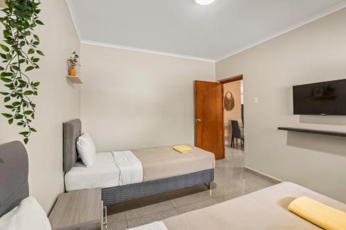 a room with two beds and a flat screen tv at Curadise Living in Willemstad