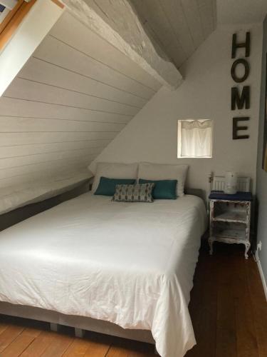 a bedroom with a white bed in a attic at Le nid Mésange in Alligny-en-Morvan