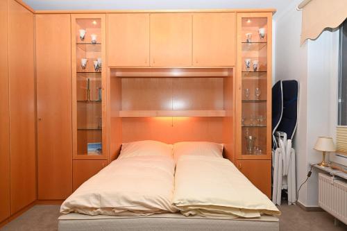 uma cama grande num quarto com armários de madeira em Ferienwohnung Ilka WE 14 em Hohwacht
