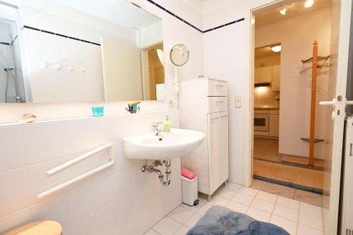 um banheiro branco com uma pia e um espelho em Ferienwohnung Ilka WE 14 em Hohwacht