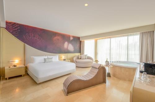 a hotel room with a bed and a bath tub at The Eden by Desire Riviera Maya All Inclusive - Couples Only in Puerto Morelos