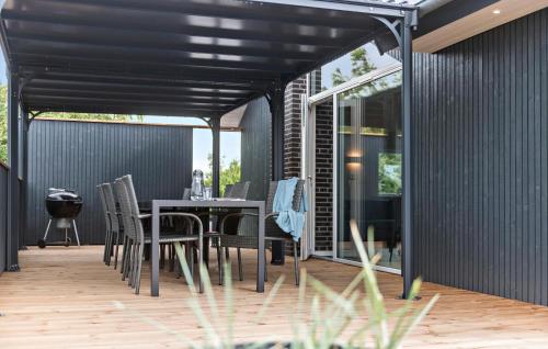 a black pergola on a patio with a table and chairs at Amazing Home In Rømø With Wifi in Vesterhede