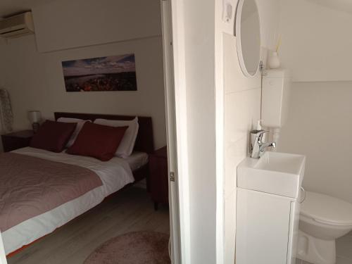 a bedroom with a bed and a sink and a toilet at Zemun Central in Zemun