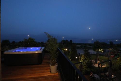 a hot tub sitting on a deck at night at Toka Hotel Restaurant in Pogradec