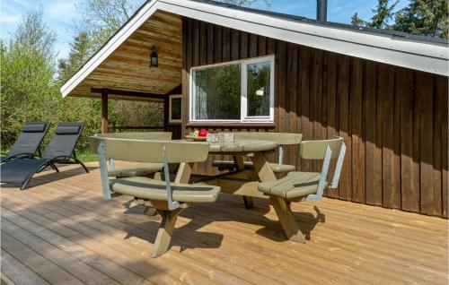 a patio with a table and chairs on a wooden deck at 3 Bedroom Nice Home In Fjerritslev in Fjerritslev