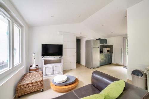 un salon avec un canapé et une télévision dans l'établissement 850m de la plage maison neuve pour 6 en foret, à Longeville-sur-Mer