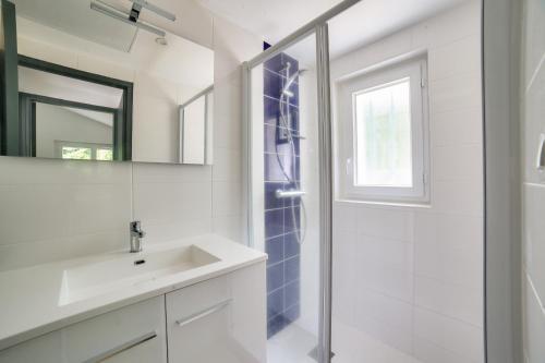 a white bathroom with a shower and a sink at 850m de la plage maison neuve pour 6 en foret in Saint-Vincent-sur-Jard