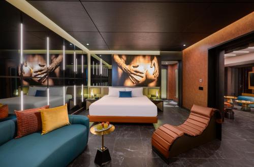 a hotel room with a bed and a couch at The Eden by Desire Riviera Maya All Inclusive - Couples Only in Puerto Morelos
