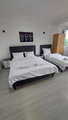 two beds in a room with white sheets at Petreski Apartments 1 in Ohrid