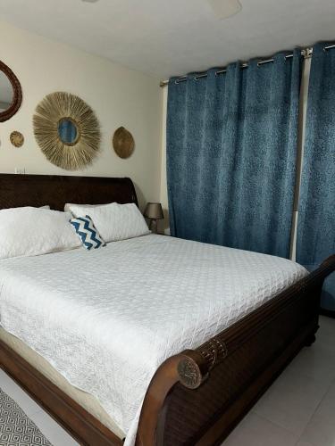 a bedroom with a bed with a blue curtain at royal at courtleigh towers in Kingston