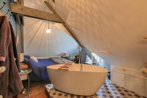 - une salle de bains avec baignoire et un lit dans une tente dans l'établissement Maison atypique pour 6 adultes et 2 enfants, à Erquy