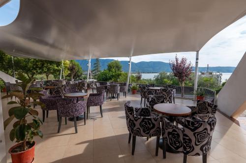 a restaurant with tables and chairs and a view of the water at Edva Resort in Vlorë