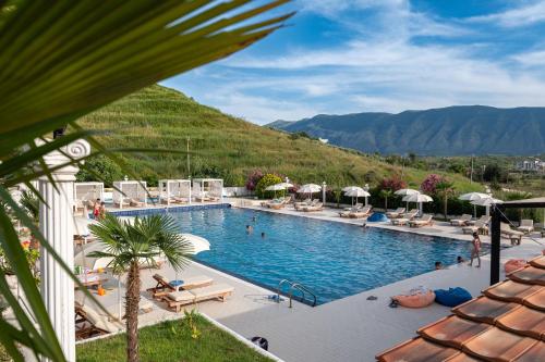 a view of a pool with mountains in the background at Edva Resort in Vlorë